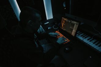 Music producer working with laptop for AI music industry article