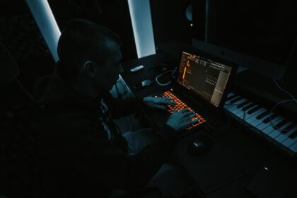 Music producer working with laptop for AI music industry article