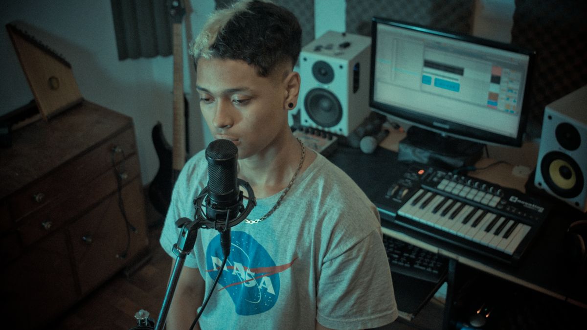 Rapper recording vocals in a home studio during debate over AI-assisted music production