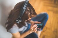 Music listener with smartphone and headphones representing social music remix culture